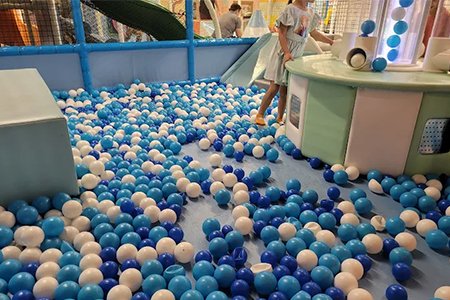 Children enjoying a fun and vibrant ball pit in an indoor playground.